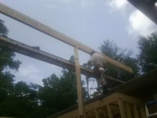 Carpenter setting a ridge beam over a new addition frame — Ice Dam Removal by Roofing Brothers in Camp Murray